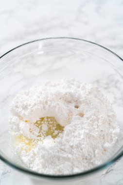 Küçük Paskalya ekmeği için limon jölesi yapmak için karışımı büyük bir karıştırıcı ile karıştırıyorum..