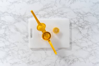 Beyaz bir kesme tahtasının üzerinde taze limon zıp zıp..