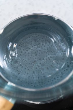 Çikolata parçacıkları ve diğer malzemeleri kaynayan suyun üzerinde karıştırarak çikolatalı şekerleme ve fıstık ezmesi karışımı hazırlıyorum..