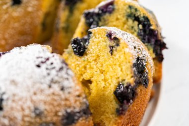 Taze pişmiş limonlu yaban mersinli kek dilimliyorum. Pudra şekerli..