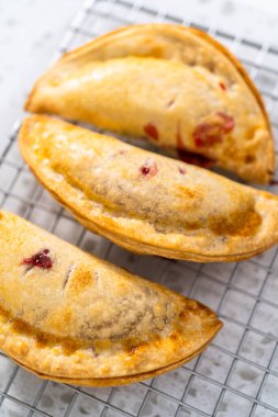 Mutfak tezgahındaki tavada taze pişmiş vişneli börek var..