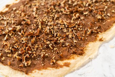 Ekmek hamurunu tarçınla doldurmak ve tarçınsız çörek pişirmek için ceviz doğramak..