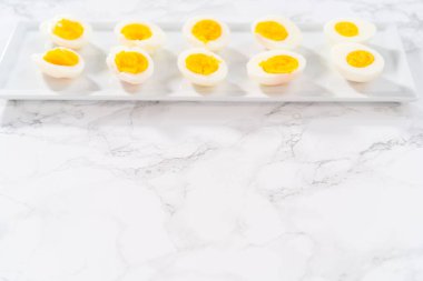 Beyaz servis tabağında dilimlenmiş haşlanmış yumurta..