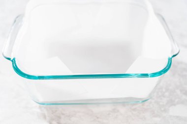 Şekerli mısır şekeri hazırlamak için kare peynirli kek tavasını kağıt kağıtla kaplamak.