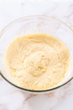 Elmalı kek ve karamel jöleli kek yapmak için büyük bir bardakta karıştırma malzemesi..