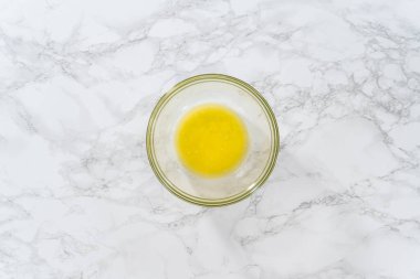 Düz yatıyordu. Tezgahta erimiş tuzsuz tereyağı çubukları.