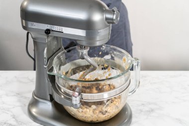 Yumuşak yulaflı kuru üzümlü cevizli kurabiyeler pişirmek için mutfak tezgahında karışımlar hazırlıyorum..