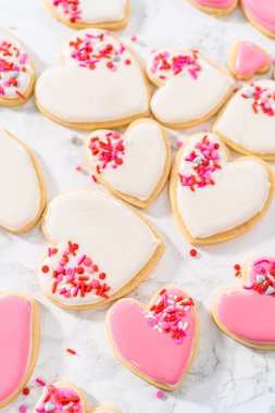 Sevgililer Günü için pembe ve beyaz kraliyet kremalı kalp şeklinde kurabiyeler..