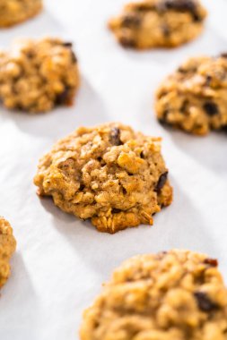 Mutfak tezgahında taze pişmiş yulaf ezmeli kuru üzümlü cevizli kurabiye..