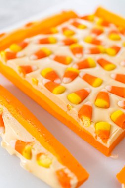 Beyaz bir kesme tahtasının üzerinde şekerli mısır şekerini kare parçalara ayırmak..