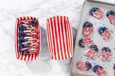 Flat lay. American flag. Red, white, and blue chocolate-covered pretzel twists.