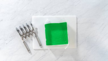 Düz yatıyordu. Kesmek için yeşil şekerlemeleri mükemmel karelere çevirmek.