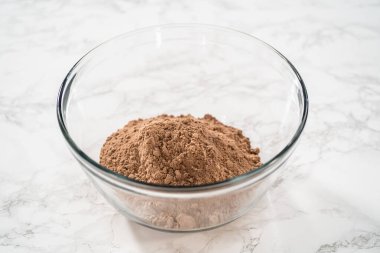 Büyük bir bardaktaki malzemeleri karıştırarak naneli çikolatalı kekler pişiriyorum..