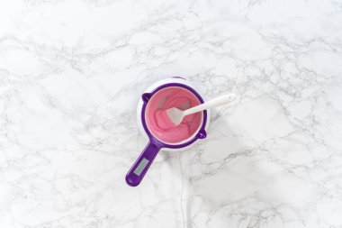 Düz yatıyordu. Panda şeklindeki kurabiyeler için çikolatalı fiyonk yapmak için şekerleme kabında pembe çikolata parçacıkları eritiyorum..