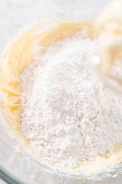 Havuçlu kek için krem peynirli pasta yapmak için malzemeleri büyük bir karıştırma kabında karıştırıyorum..