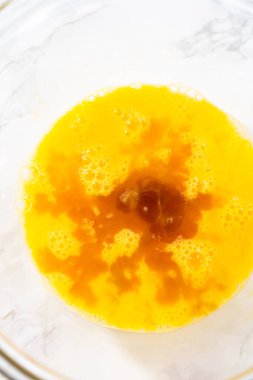 Mixing wet ingredients in a large glass mixing bowl to bake chocolate cookies with chocolate hearts for Valentines Day.