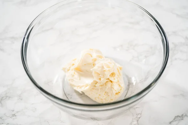 ガラス製のミキシングボウルに電動ハンドミキサーでバタークリームを泡立て ペパーミントバタークリームの霜取りを準備します — ストック写真