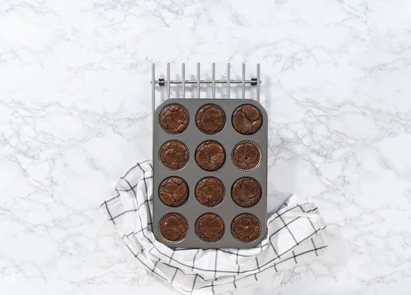 Flat lay. Cooling freshly baked chocolate peppermint cupcakes on a kitchen counter.