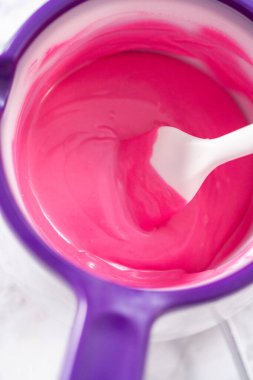 Çikolata kaplı çilek hazırlamak için çikolata parçalarını eritmek..