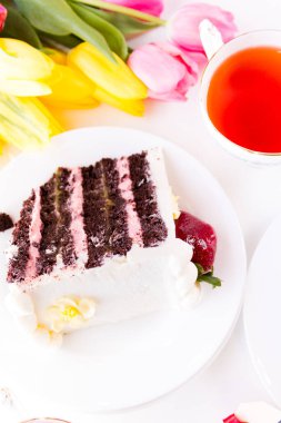 beyaz çikolatalı krem peynirin dondurucuda 6 kat dolu limon lor ve çilek mus, çikolatalı kek ile yapılan çikolatalı çilekli limonlu torte kaplı.