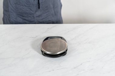 Fırında pişmiş patates. Mutfak terazisinde cam bir kasede çiğ patates ölçüyorum..