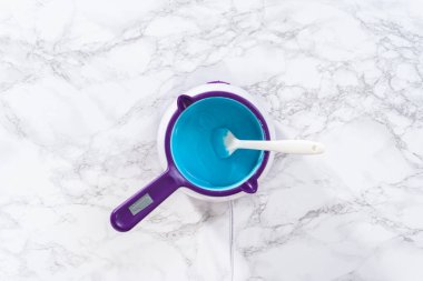 Deniz kızı çikolatalı çubuk kraker hazırlamak için eritme kabında çikolata eritmek..