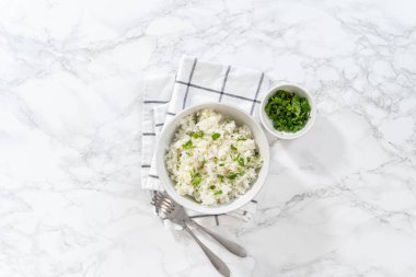Düz yatıyordu. Cilantro Lime Rice. Beyaz seramik kaselerde taze maydanozla süslenmiş kişniş limonlu pirinç servis ediliyor..