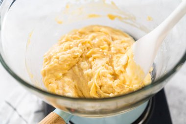 Eriyen beyaz çikolata parçaları ve diğer malzemeler kaynamış suyun üzerine karıştırıp çubuk şekerleme hazırlıyor..