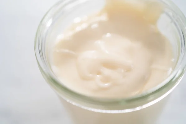 Cream cheese glaze in small glass jat.