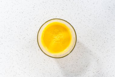 Düz yatıyordu. Basit bir vanilyalı kek pişirmek için malzemeleri cam bir kapta çırpma kabıyla karıştırıyorum..