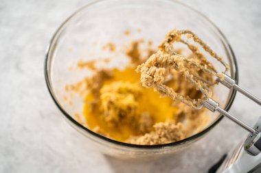 Büyük bir bardaktaki malzemeleri mutfak mikseriyle karıştırıp çikolatalı kurabiyeleri naneli cipsle pişirmek..