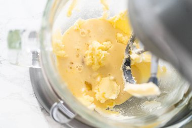 Mixing ingredients in kitchen electric mixer to bake American flag mini cupcakes.