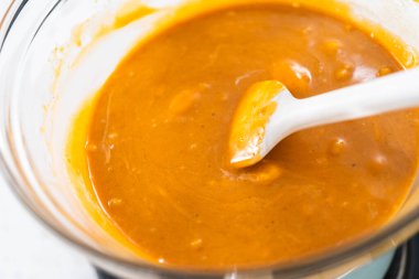 Çikolata parçacıkları ve diğer malzemeleri kaynayan suyun üzerine karıştırıp kabak aromalı şekerleme hazırlıyorum..