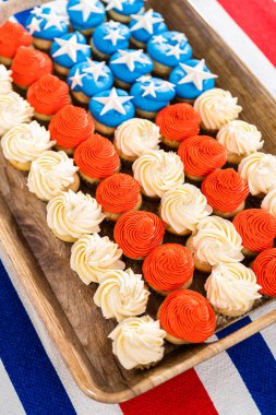 Arranging mini vanilla cupcakes in the shape of the American flag.