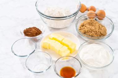 Bardaktaki ölçülü malzemeler karıştırma kaseleri kırmızı kadife kekler ve beyaz çikolatalı ganache kreması..