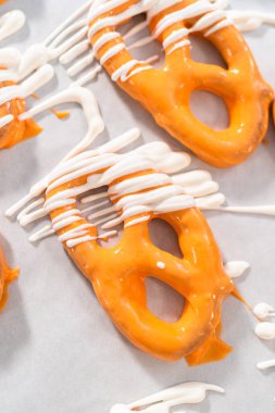 Çikolata soslu krakerlerin üzerine erimiş çikolata serpiştirmek..