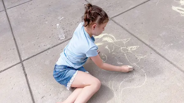 Kleines Mädchen Zeichnet Einem Sommertag Kreidekunst Auf Einer Vorstadteinfahrt — Stockfoto