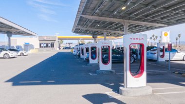 Baker, California, ABD-3 Aralık 2022-Gün boyunca Tesla bir süper şarj istasyonunda yüksek hızlı şarj altyapısını uygun ve verimli bir şekilde kullanan bir Tesla aracı görüldü.