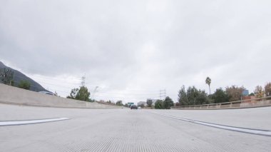 Yağmurlu bir kış gününün ortasında, Los Angeles, Kaliforniya yakınlarındaki HWY 134 'te, yağmur damlalarıyla kaplı lenslerle atmosferi yakalıyor, ve bu yolculuğa benzersiz ve dengesiz bir perspektif ekliyor..