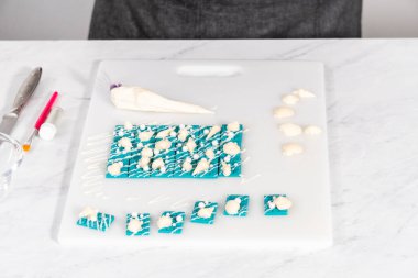 Çiseleyen beyaz çikolata ve üzerine beyaz inci şekeri serpiştiren mini çikolata ozanı.