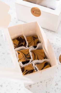 Fıstık ezmeli ev yapımı çikolatalı şekerlemeler beyaz bir hediye kutusuna konuyor..