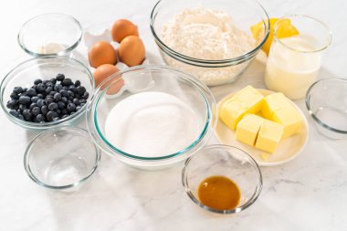 Limonlu yaban mersinli kek pişirmek için bardakların içindeki ölçülü malzemeler..