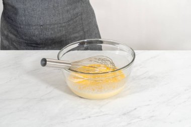 Limonlu yaban mersinli kek pişirmek için büyük bir bardakta ıslak malzemeler karıştırıyorum..