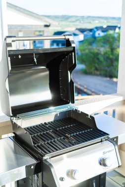 Denver, Colorado, ABD-Haziran 3, 2023-Webers iki ocaklı ızgara, kapağı davetkar bir şekilde açık, bir banliyö evinin balkonunda düşünceli bir şekilde hazırlanmış,
