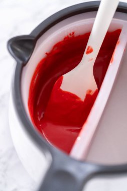 Çikolata, sıcak çikolata bombaları hazırlamak için bir şeker tenceresinde erir..