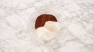 Düz yatıyordu. Adım adım. Çikolatalı kek pişirmek için bardaktaki malzemeleri karıştırıyorum..