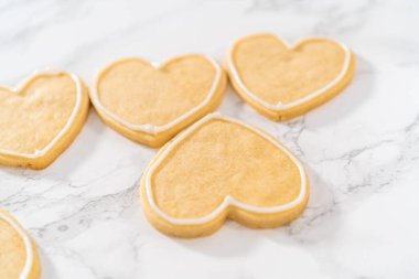 Sevgililer Günü için pembe ve beyaz kraliyet kremalı kalp şeklinde kurabiyeler..