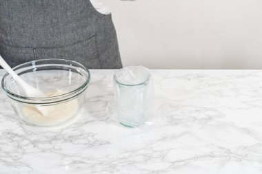 Şekerli kurabiyeleri süslemek için boru torbalarına ev yapımı kraliyet kreması aktarılıyor..