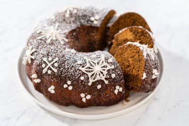 Dilimlenmiş zencefilli kek karamel dolgulu, kremalı pasta ve kek tabağında toz şeker..