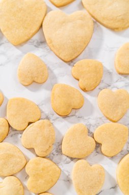 Sevgililer Günü için pembe ve beyaz kraliyet kremalı kalp şeklinde kurabiyeler..